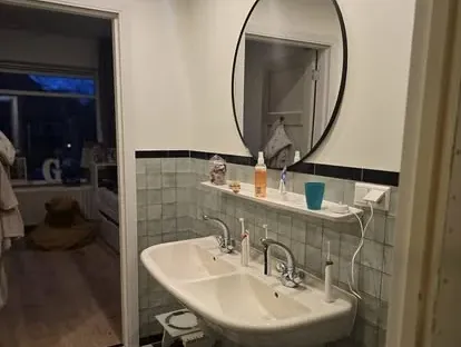 Badkamerrenovatie met zorgvuldig afgestemd sanitair, tegelwerk en verlichting.