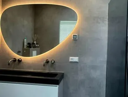 Maatwerk sanitair en tegelwerk in een gerenoveerde badkamer.