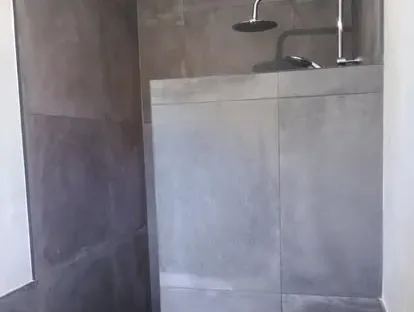 Badkamerrenovatie met zorgvuldig afgestemd sanitair, tegelwerk en verlichting.