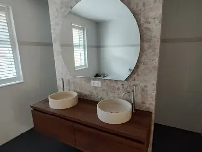 Badkamerrenovatie met zorgvuldig afgestemd sanitair, tegelwerk en verlichting.