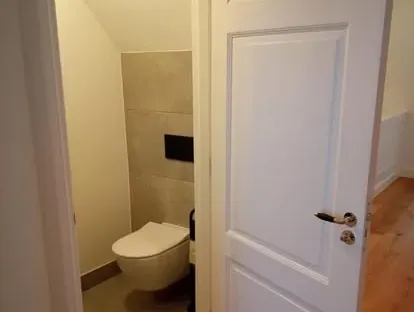 Badkamerrenovatie met zorgvuldig afgestemd sanitair, tegelwerk en verlichting.