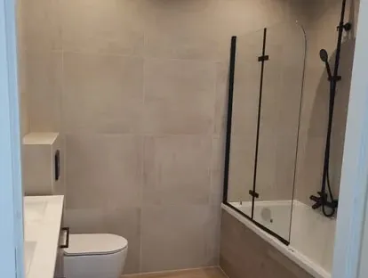 Badkamerrenovatie met zorgvuldig afgestemd sanitair, tegelwerk en verlichting.