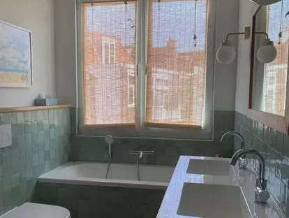 Badkamerrenovatie met zorgvuldig afgestemd sanitair, tegelwerk en verlichting.