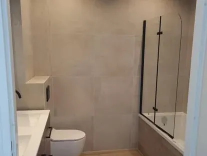 Badkamerrenovatie met zorgvuldig afgestemd sanitair, tegelwerk en verlichting.