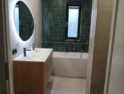 Badkamerrenovatie met zorgvuldig afgestemd sanitair, tegelwerk en verlichting.