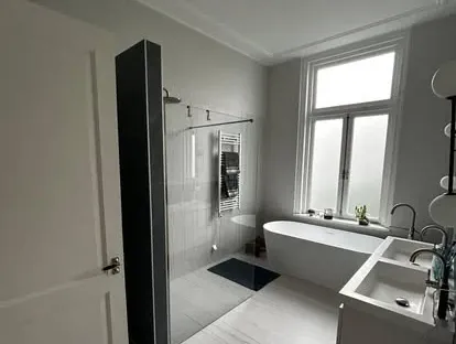 Maatwerk sanitair en tegelwerk in een gerenoveerde badkamer.