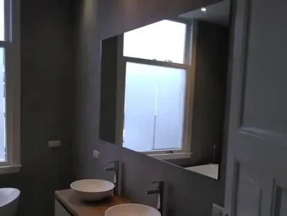 Badkamerrenovatie met zorgvuldig afgestemd sanitair, tegelwerk en verlichting.