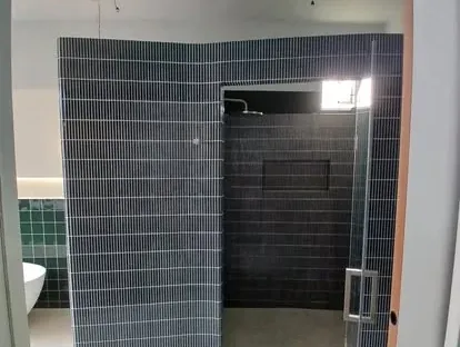 Maatwerk sanitair en tegelwerk in een gerenoveerde badkamer.
