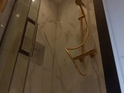 Badkamerrenovatie met zorgvuldig afgestemd sanitair, tegelwerk en verlichting.