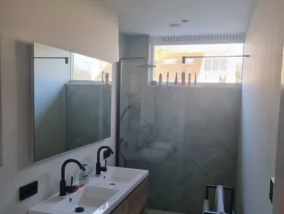 Badkamerrenovatie met zorgvuldig afgestemd sanitair, tegelwerk en verlichting.