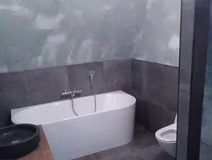 Maatwerk sanitair en tegelwerk in een gerenoveerde badkamer.