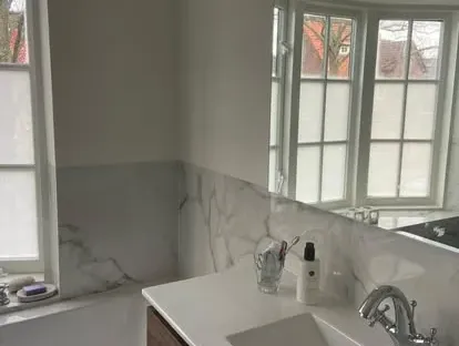 Badkamerrenovatie met zorgvuldig afgestemd sanitair, tegelwerk en verlichting.