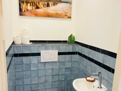 Maatwerk sanitair en tegelwerk in een gerenoveerde badkamer.