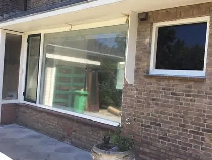 Vernieuwde buitenruimte en gevelafwerking bij een woningrenovatie.