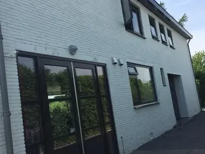 Vernieuwde buitenruimte en gevelafwerking bij een woningrenovatie.