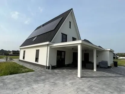 Vernieuwde buitenruimte en gevelafwerking bij een woningrenovatie.