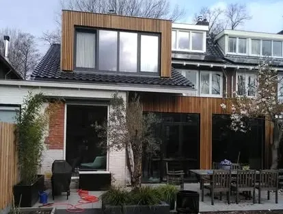Vernieuwde buitenruimte en gevelafwerking bij een woningrenovatie.
