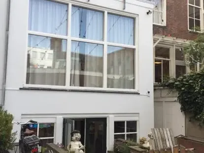 Vernieuwde buitenruimte en gevelafwerking bij een woningrenovatie.