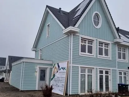 Vernieuwde buitenruimte en gevelafwerking bij een woningrenovatie.