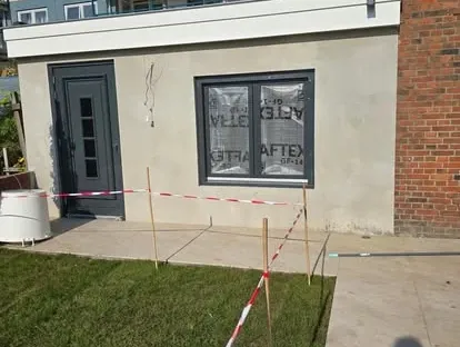 Vernieuwde buitenruimte en gevelafwerking bij een woningrenovatie.