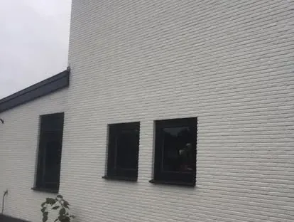 Vernieuwde buitenruimte en gevelafwerking bij een woningrenovatie.