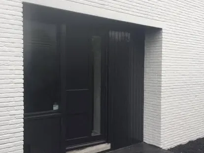 Vernieuwde buitenruimte en gevelafwerking bij een woningrenovatie.
