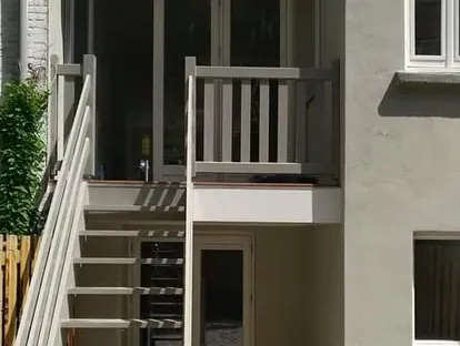 Vernieuwde buitenruimte en gevelafwerking bij een woningrenovatie.