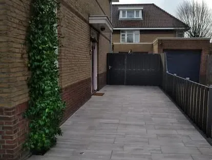 Vernieuwde buitenruimte en gevelafwerking bij een woningrenovatie.