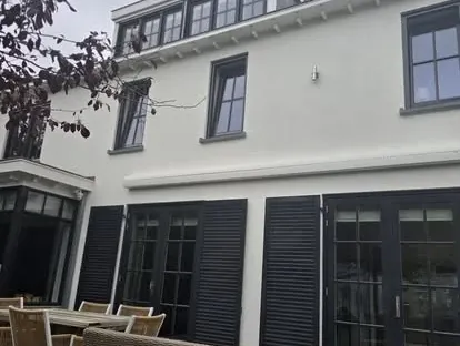 Vernieuwde buitenruimte en gevelafwerking bij een woningrenovatie.